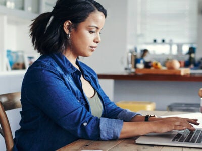 A woman typing on her laptop