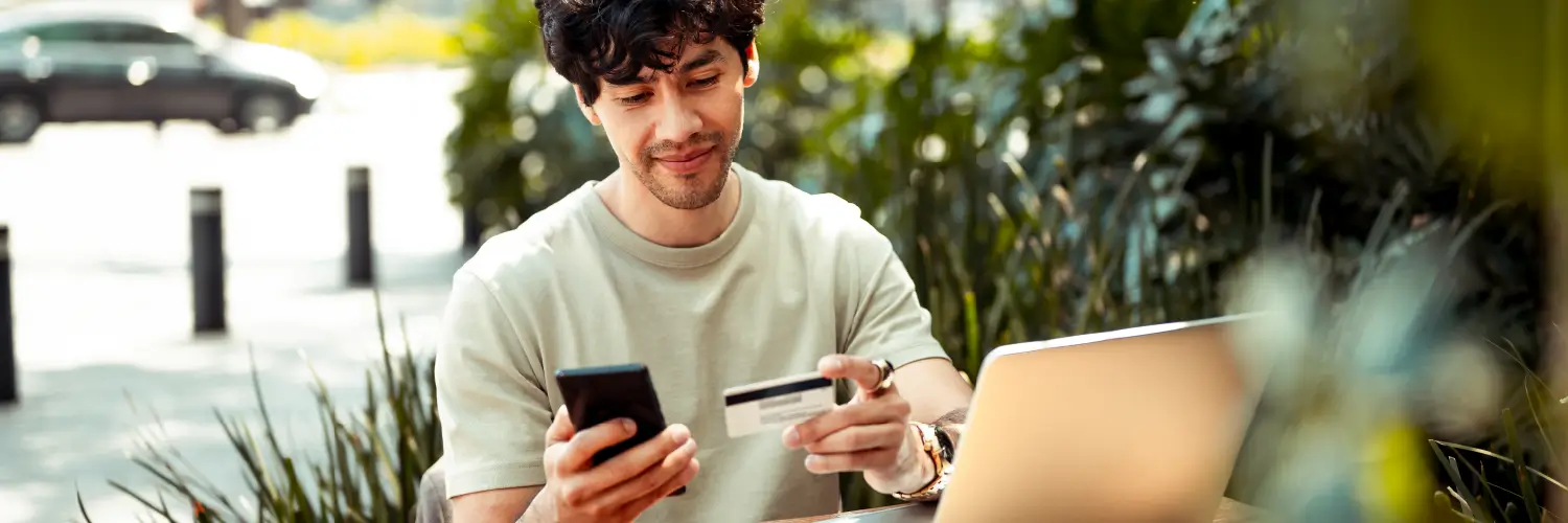 Man outside on patio making an online purchase with his PayPal credit card.