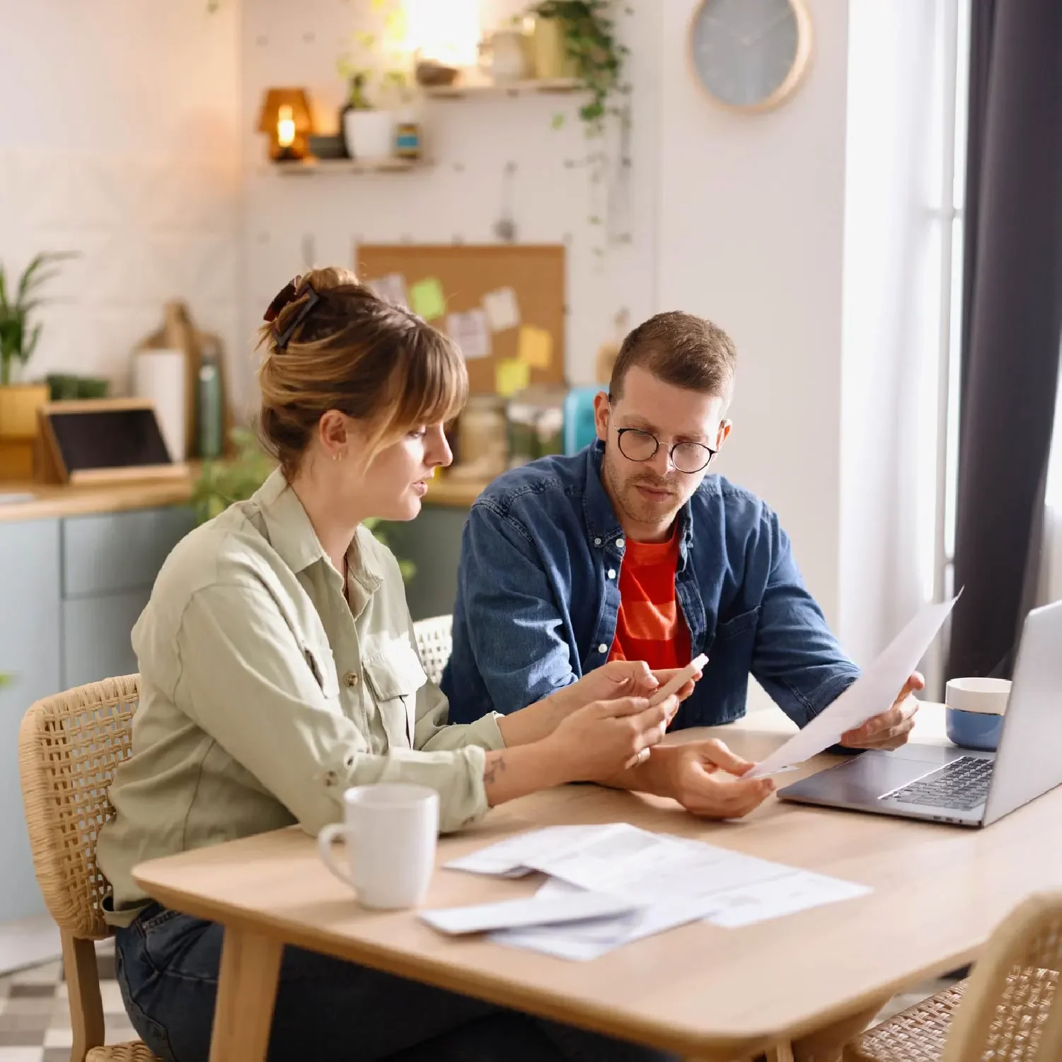 Husband and wife at their kitchen table looking at their credit reports.